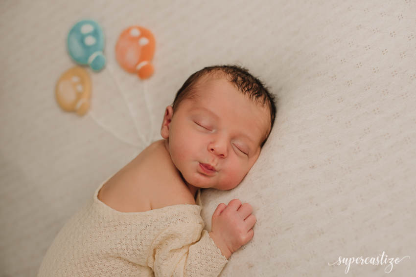 fotografia de bebé recien nacido en puf con globitos supercastizo jaen