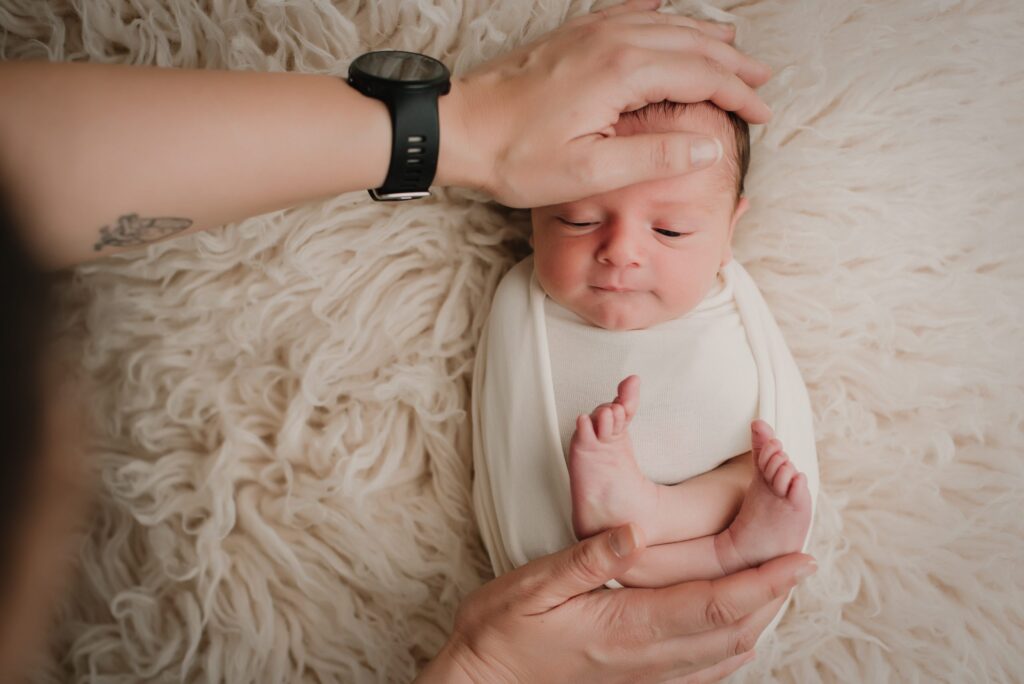 fotografo calmando a recien nacidod urante sesión new born supercastizo, jaén