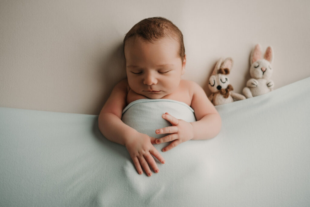 sesión newborn en Jaén con bebé dormido tapadito con una sábana Jaén Supercastizo