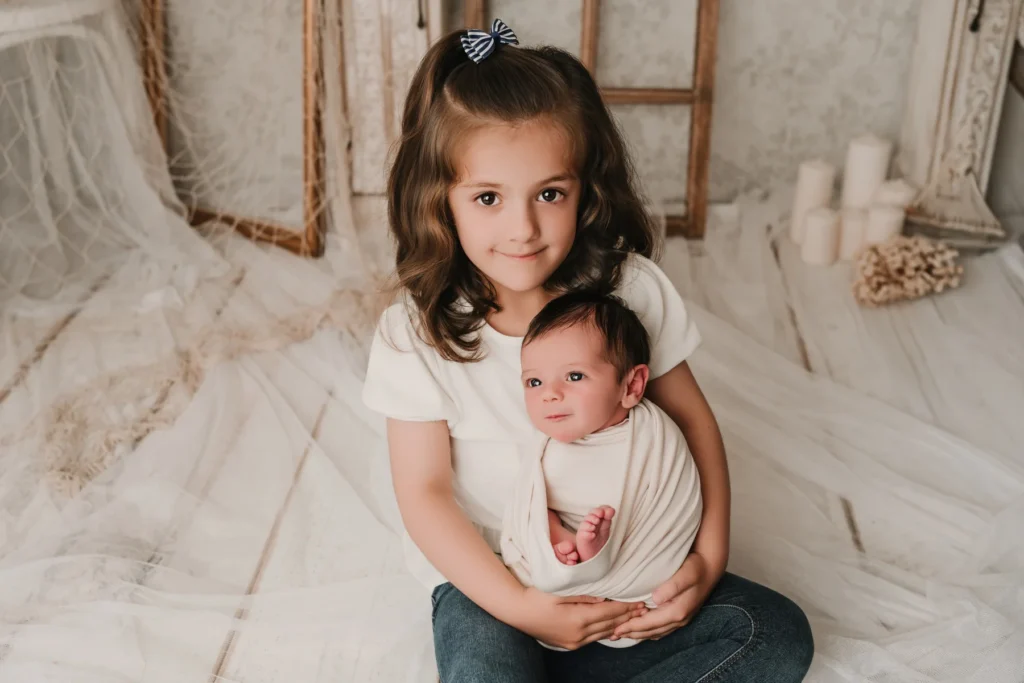 Hermana abrazando a su hermano bebé durante una sesión newborn en Jaén.