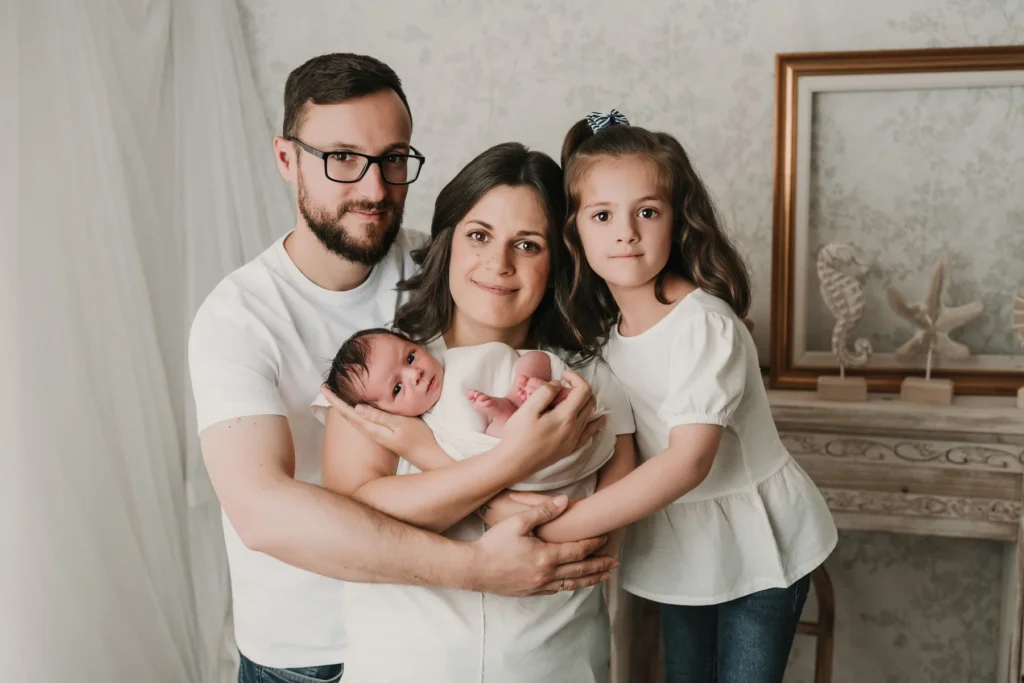 Padres abrazando a su bebé durante una sesión newborn en Jaén.