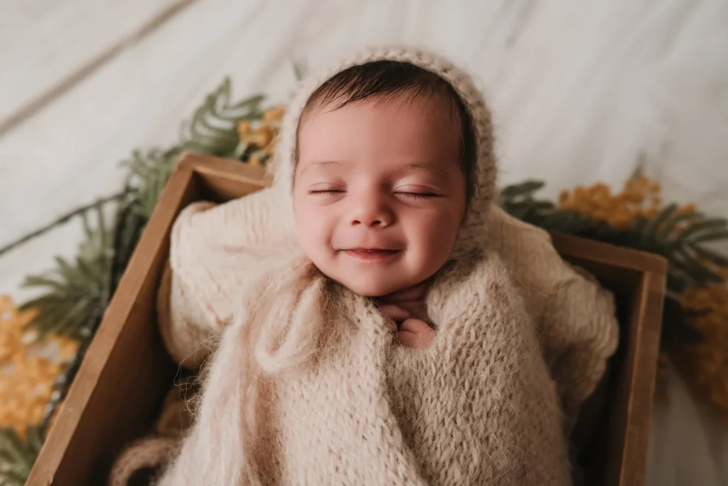 Primer plano newborn sonriendo en sesion tranquila